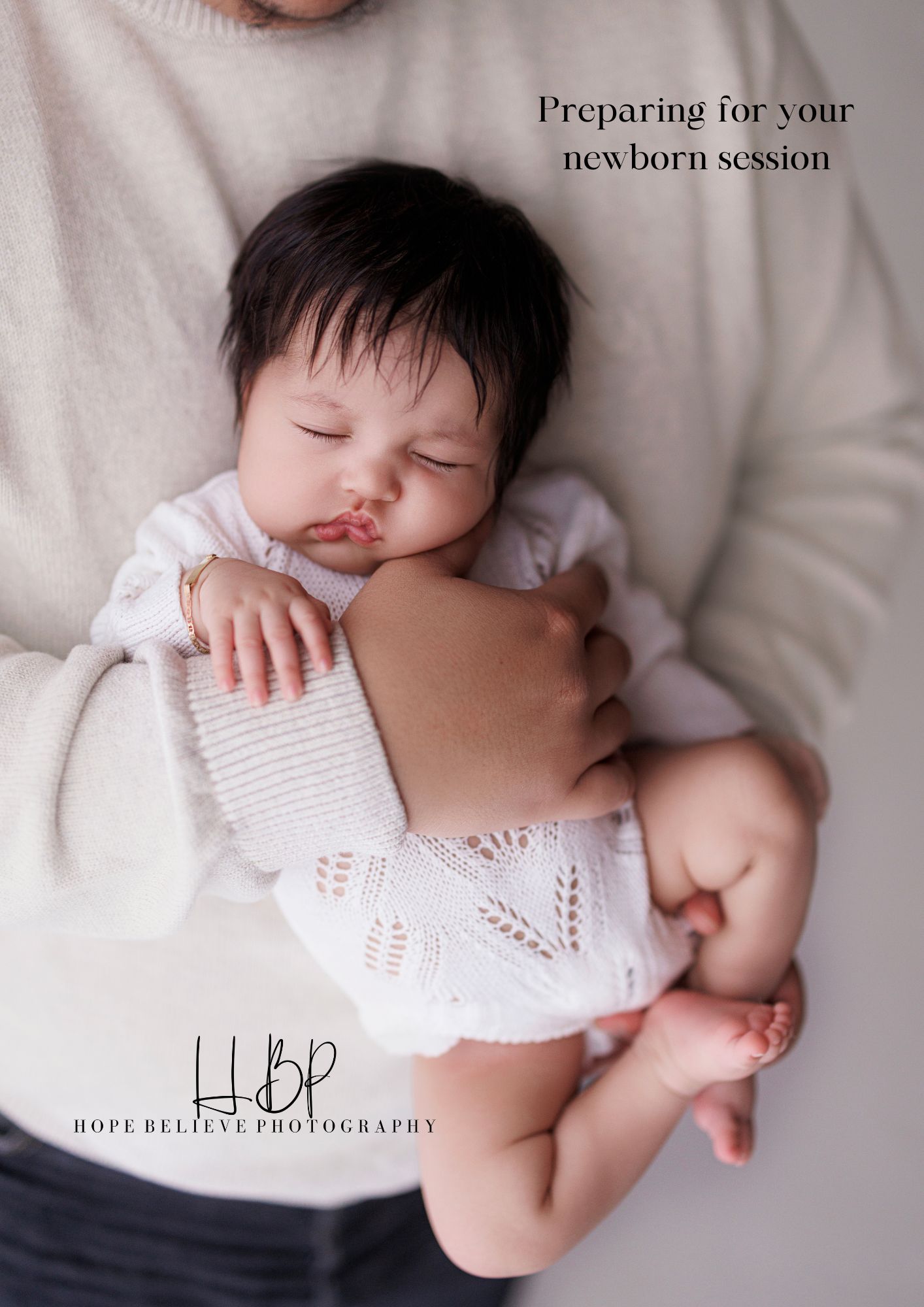 Newborn baby sleeping peacefully in parent's arms, wrapped in white knit blanket, Hope Believe Photography session guide.