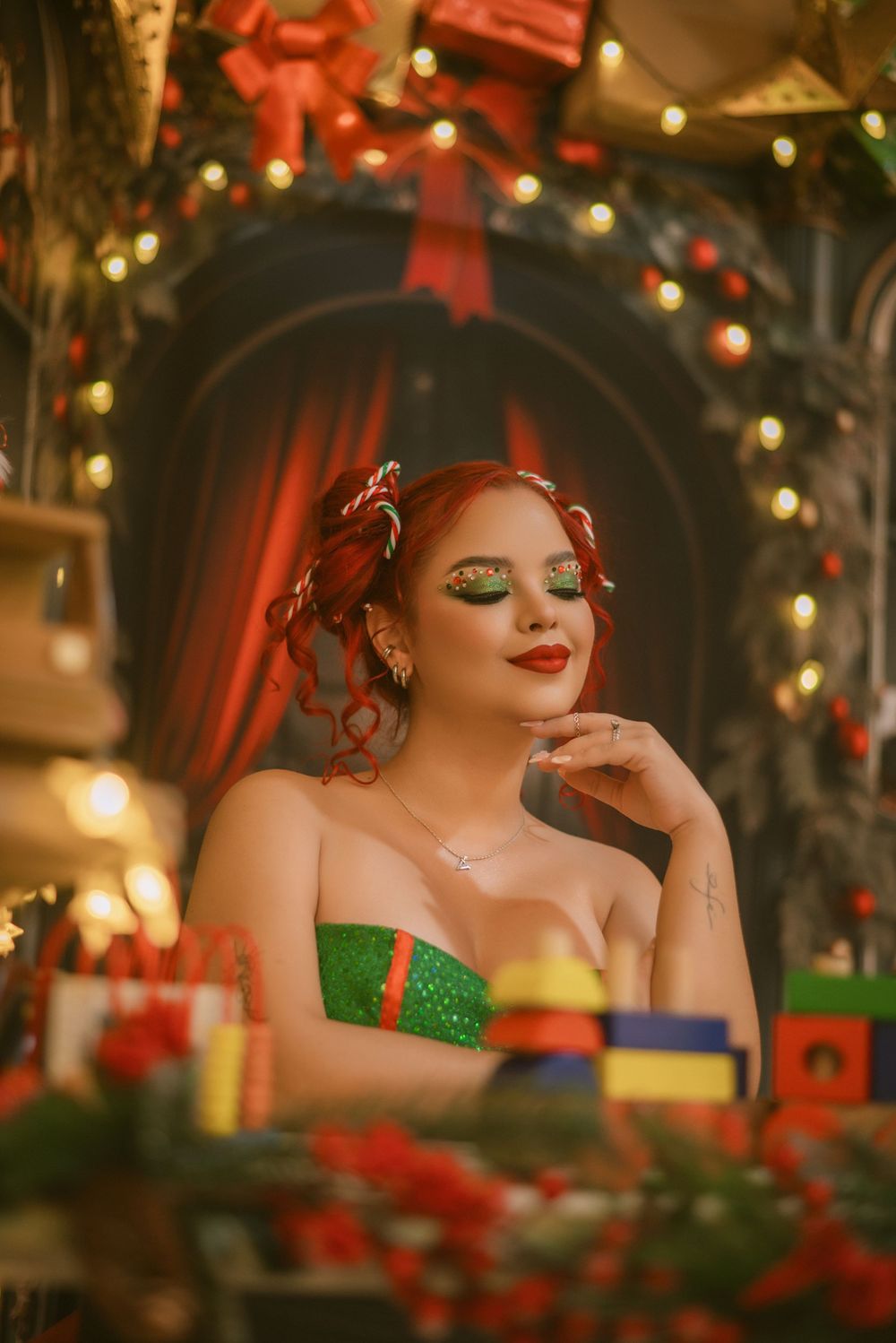 Glamorous holiday portrait with festive decorations and twinkling lights in background.