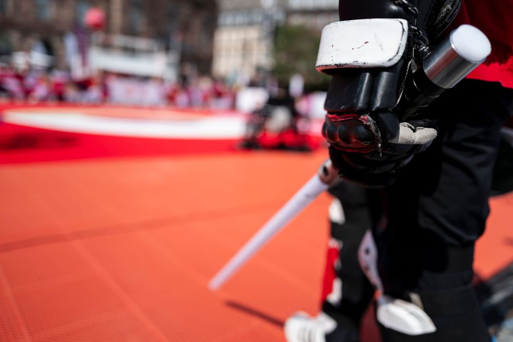 Close-up of camera equipment with red surface in background at sporting event.