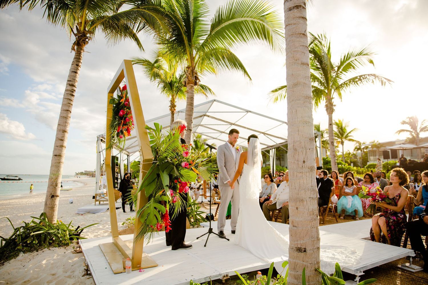 A series of tropical beach wedding ceremony photos with palm trees and ocean views at sunset.