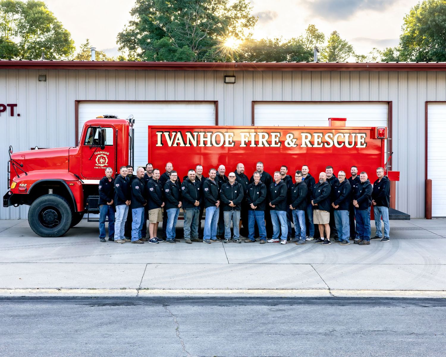 Ivanhoe Fire and Rescue team posing in front of a red fire truck outside their station.