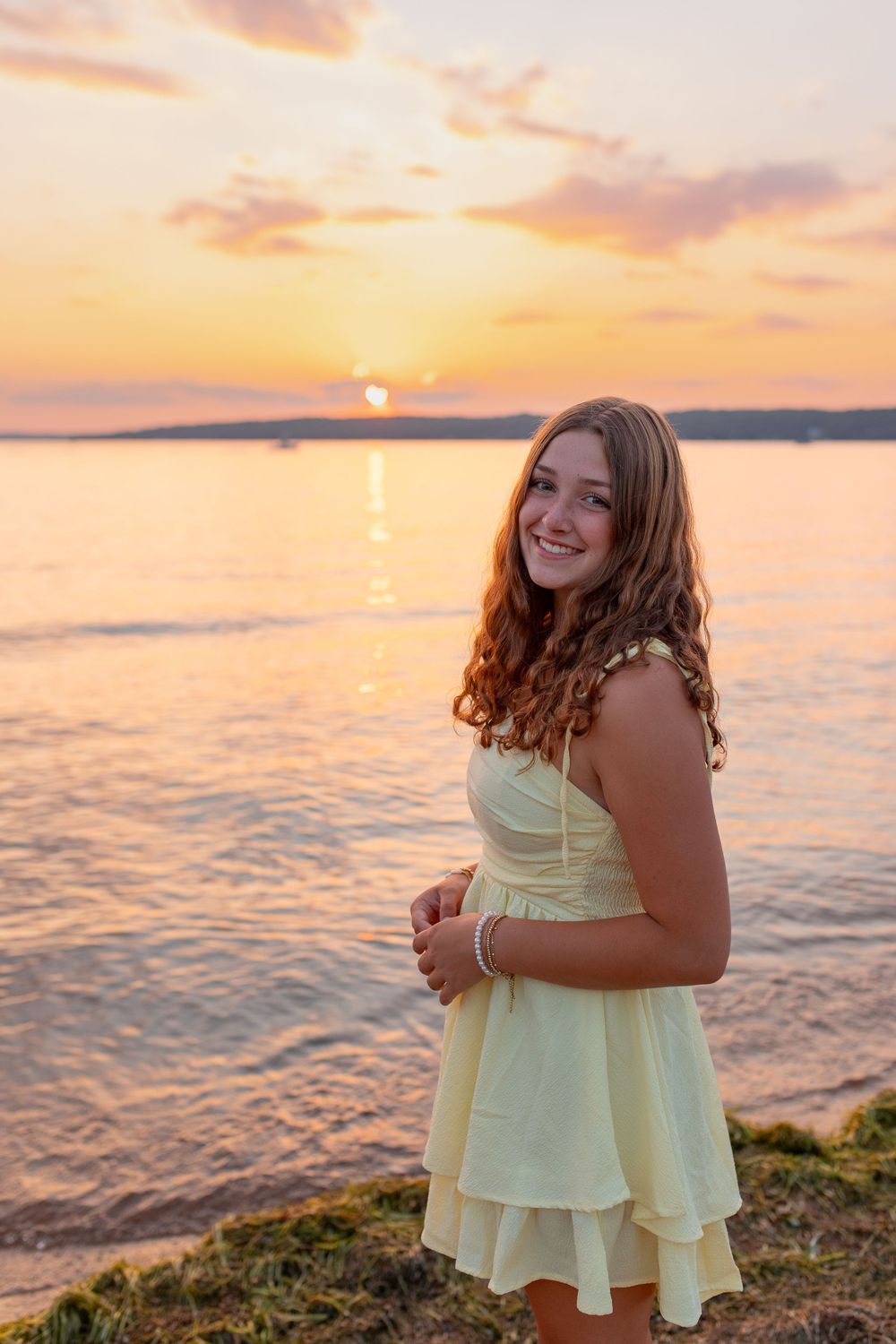 Sunny beach photoshoot at sunset with yellow sundress and ocean views.