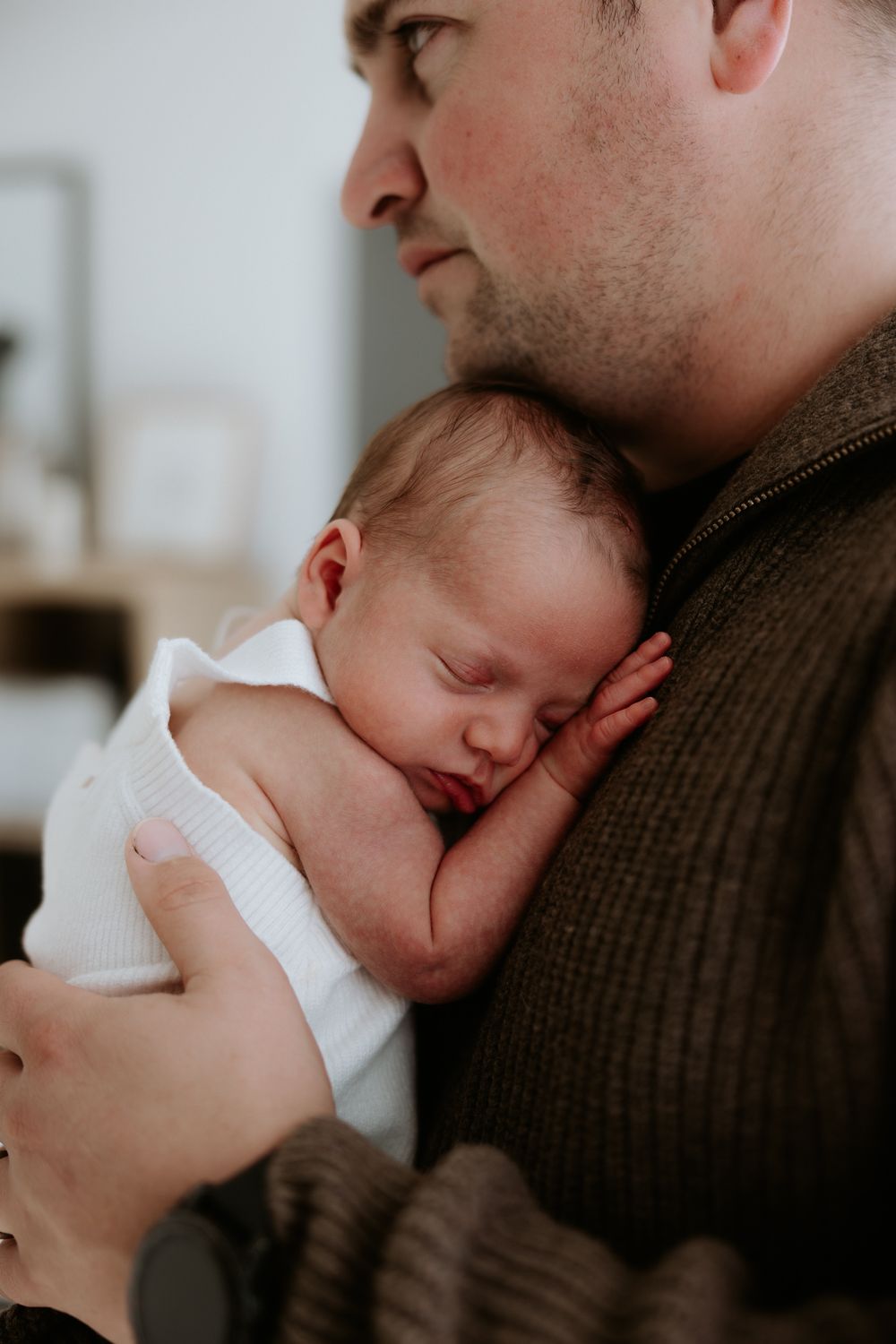 A parent tenderly cradles and comforts a sleeping baby in a heartwarming sequence of intimate moments.
