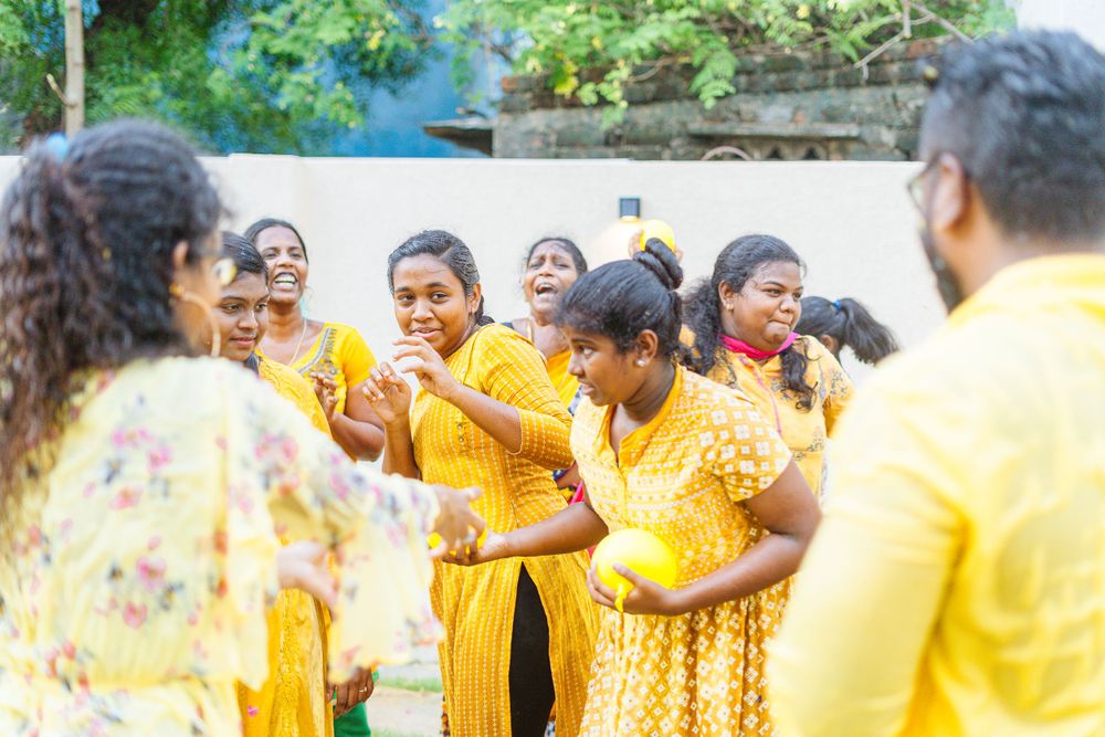 A group wearing bright yellow traditional attire gathered in celebration outdoors.