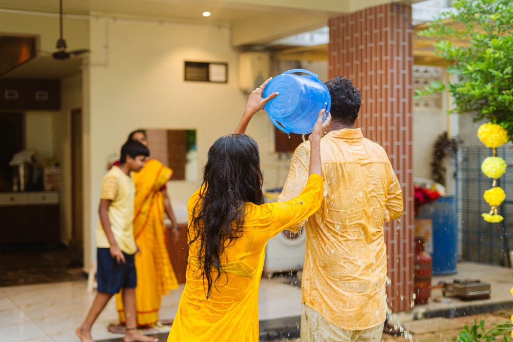 Participants in yellow outfits participate in a traditional ceremony outdoors.