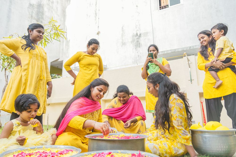 Group engaged in traditional ceremony activities while wearing yellow ethnic clothing.