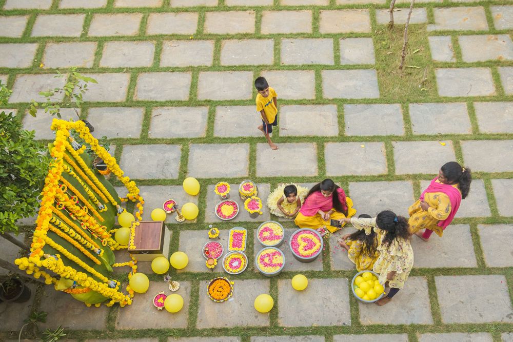 Aerial view of traditional ceremony setup with yellow decor and food arrangements.