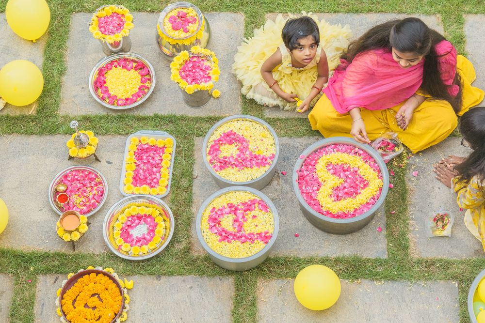 Overhead shot of traditional Indian ceremony with floral arrangements and yellow decorations.