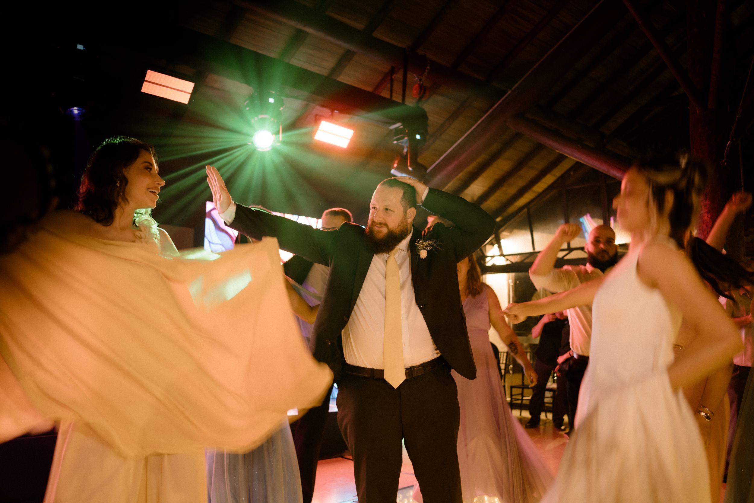 Lively dance celebration with dramatic lighting and flowing dresses in motion.