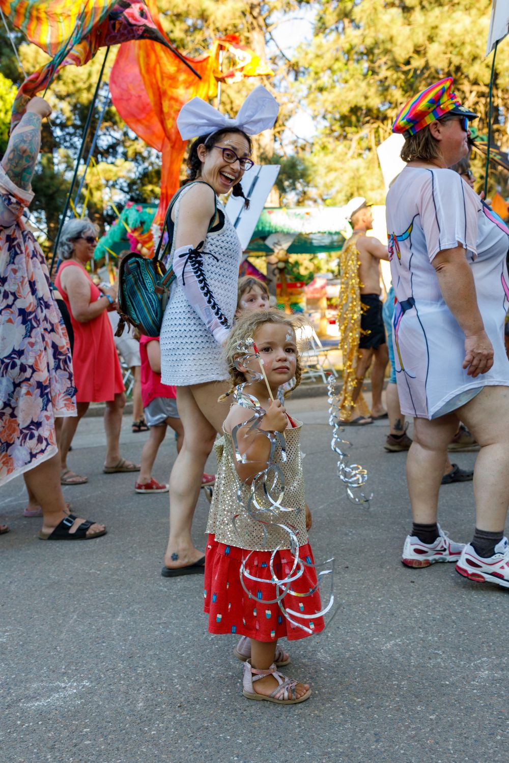 Festival celebration with bubbles and colorful flags as people enjoy outdoor activities.