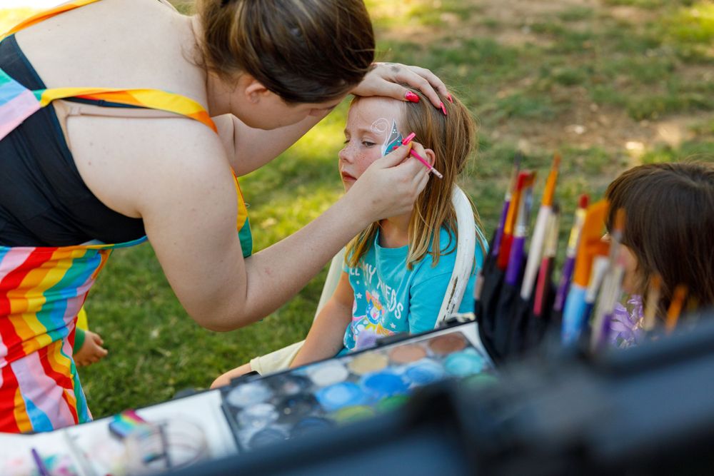 Face painting session at an outdoor festival or community event.