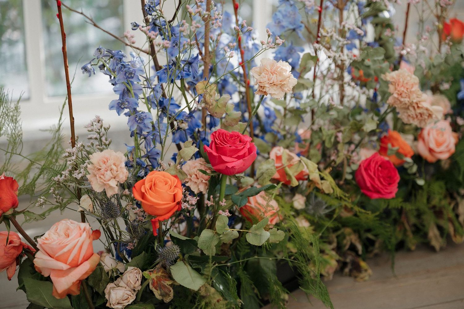 peach, orange, pink, blue flower arrangement in the chapel at The Peach Orchard wedding venue