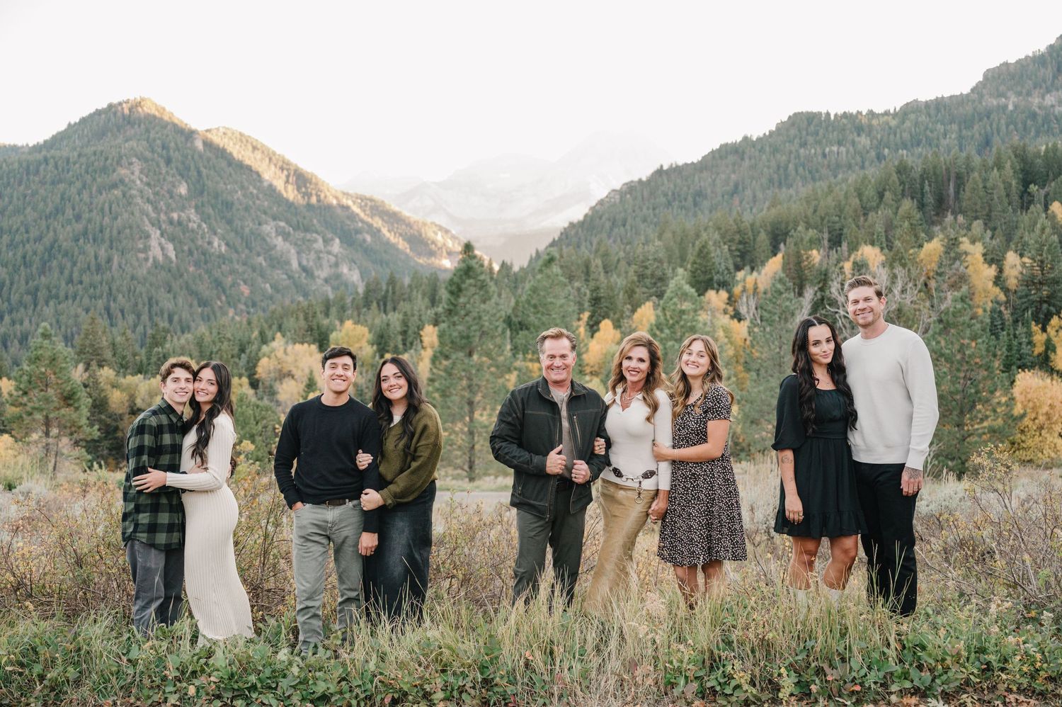 Group portrait against a backdrop of mountain scenery during golden hour in autumn.