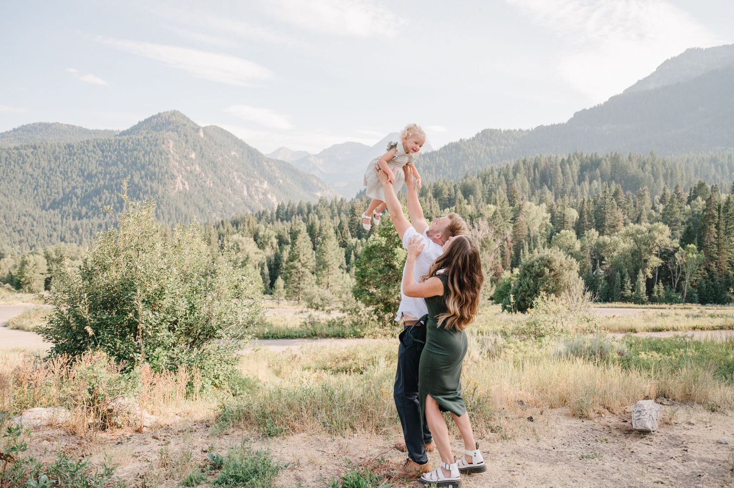 Beautiful candid family moment in a mountain valley with dramatic peaks in the background.