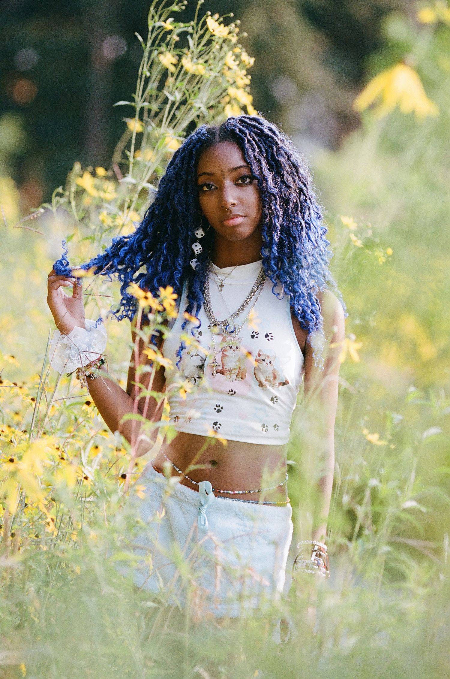 A candid outdoor portrait in a wildflower meadow with yellow blooms and natural sunlight.