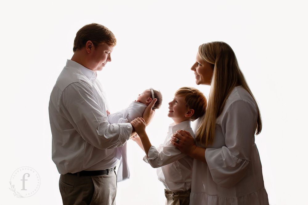 Beautiful family newborn portrait with parents and older sibling in white coordinating outfits, Summerville SC studio