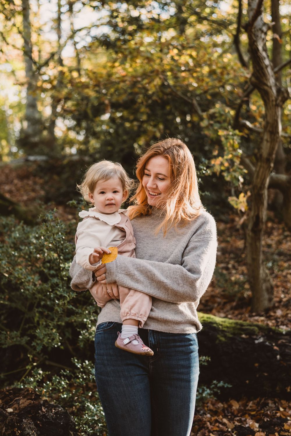 A tender autumn moment captured in the woods with warm sunlight filtering through golden leaves.