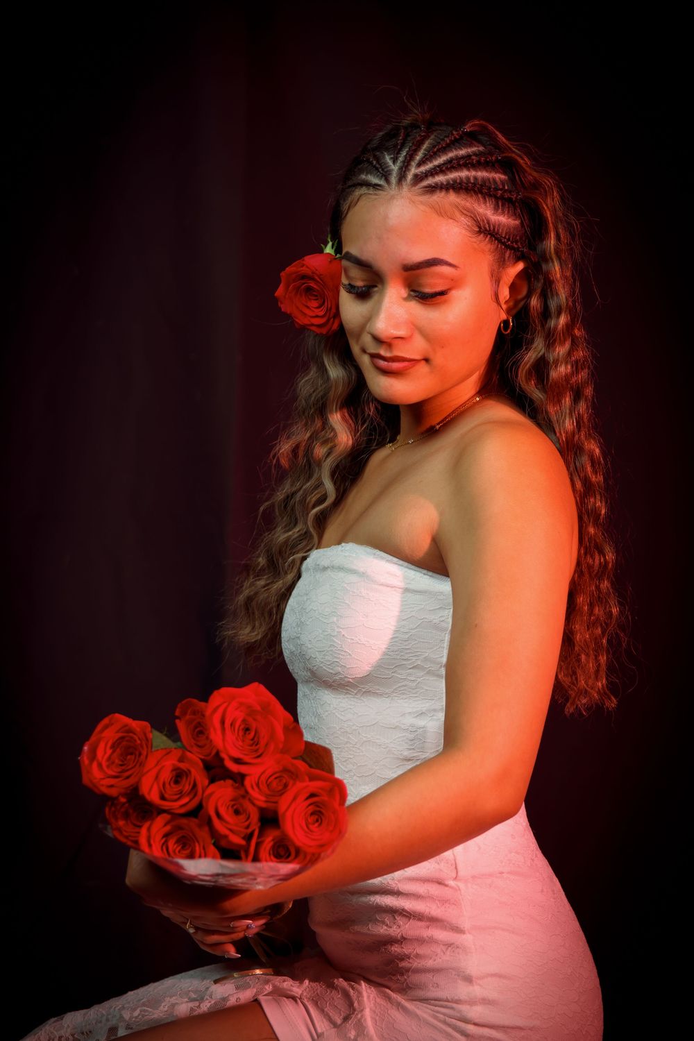 A beautiful girl holding red roses with a black background