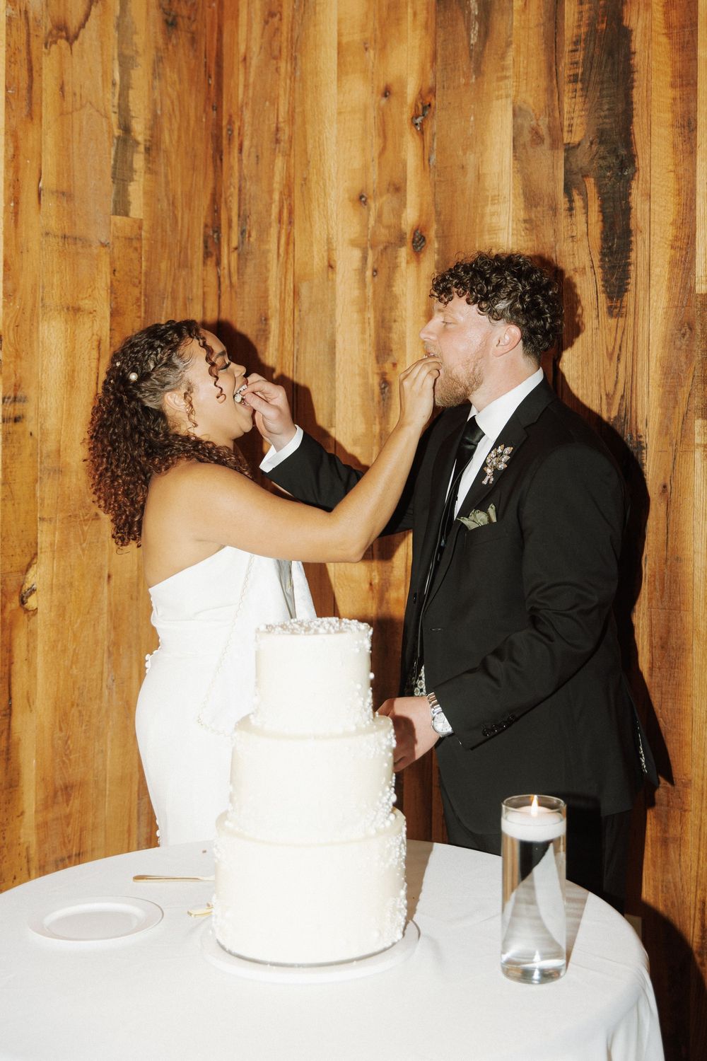 A sequence of progressive wedding cake cutting photos showing newlyweds slicing into a white tiered cake together.