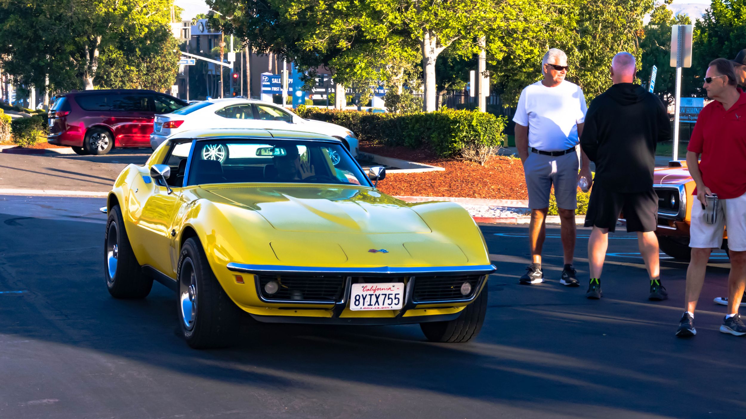 Classic yellow Chevrolet Corvette displayed at an outdoor car show.