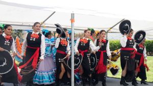 Dancers in traditional Mexican costumes performing at an outdoor cultural festival.