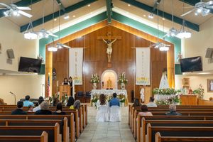 Interior of a modern church with wooden pews and green architectural accents.