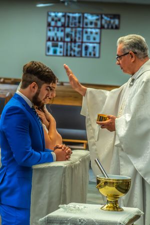 Religious ceremony with clergy in white robes performing sacred rites.