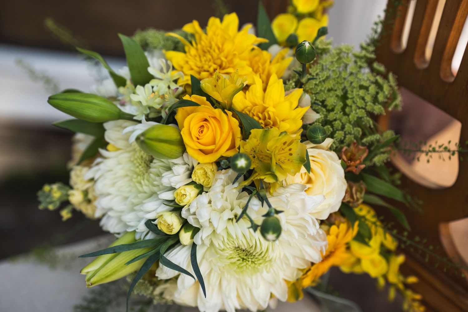 Bright yellow and white floral arrangements with roses, lilies and chrysanthemums.