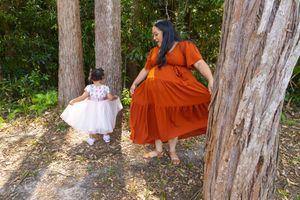 A whimsical forest scene with matching poses in complementary dress colors.