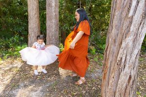 A candid forest photoshoot showing playful interaction between two people in contrasting outfits.