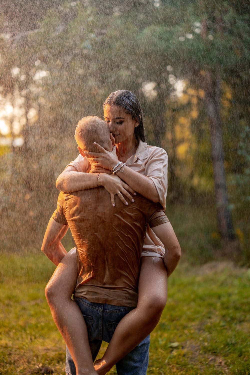 Intimate moment captured at sunset with rain falling in a forest setting.