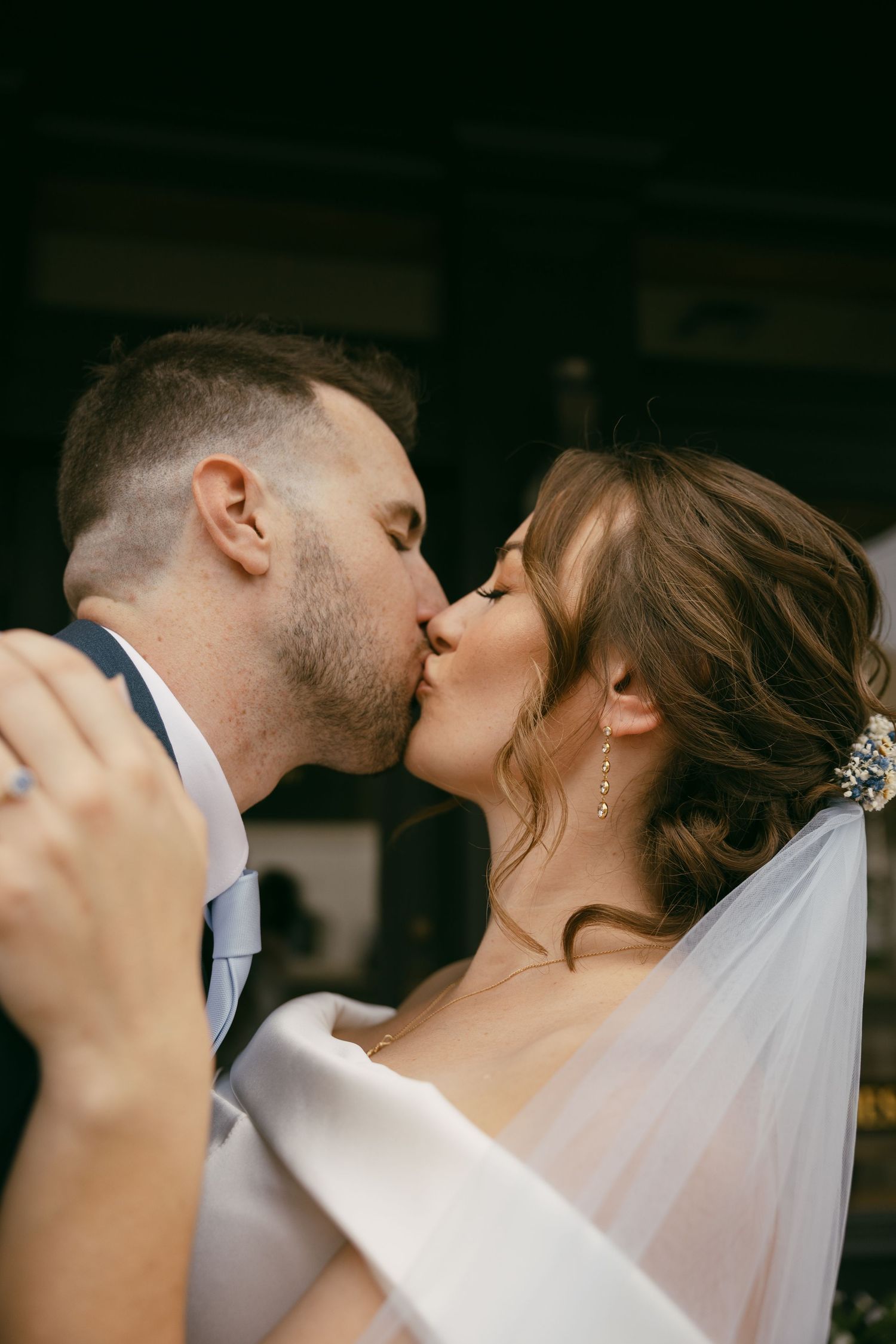An intimate dance moment under a greenhouse canopy with string lights and green foliage.