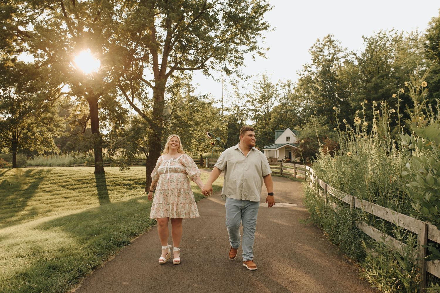 Engaged couple walking hand-in-hand along a garden path at Inniswood Metro Gardens in Westerville, Ohio.