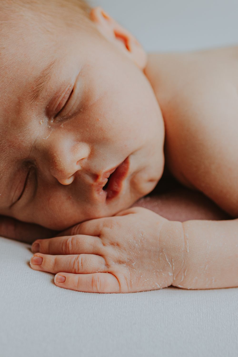 Serene close-up portrait of sleeping newborn baby with soft natural lighting.