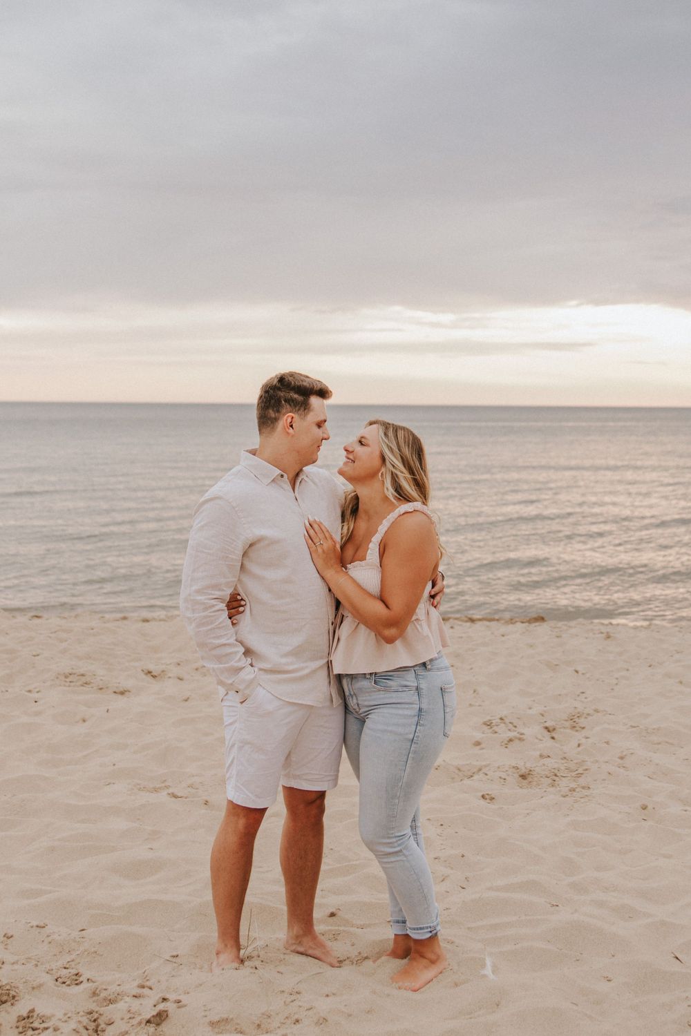 A couple sharing a romantic moment on the beach at sunset.