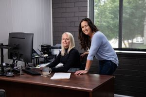 Two professionals working together at a desk in a modern office setting.