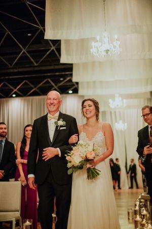 Wedding ceremony moment with white drapery and chandeliers creating an elegant atmosphere.