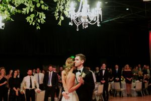 A romantic first dance under a crystal chandelier at an elegant wedding reception.