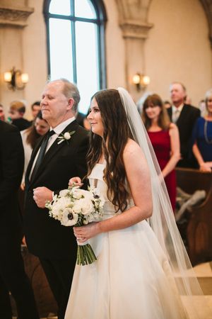 Traditional church ceremony processional with white floral bouquet.