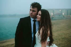 Romantic coastal portrait with misty oceanfront backdrop.