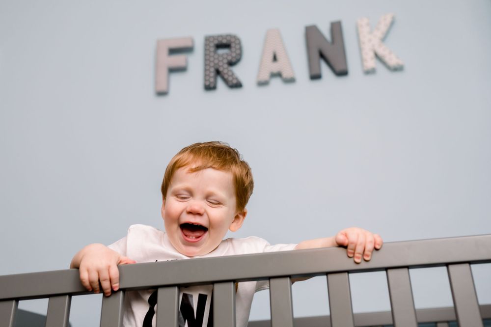 Series of playful shots showing a child peeking over a white railing with letters spelling FRANK.