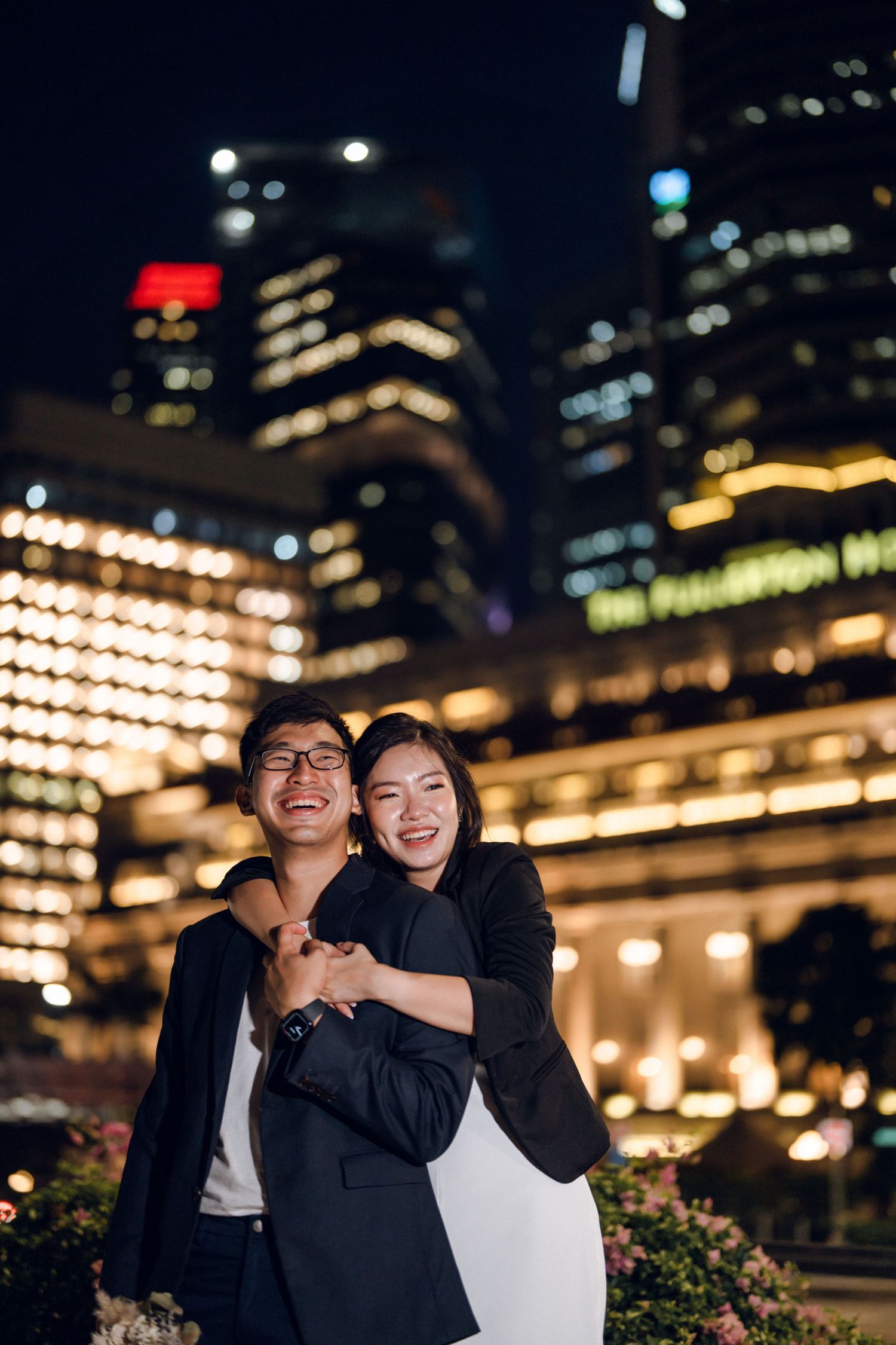 Romantic evening portrait with glowing lanterns and city lights creating magical ambiance.