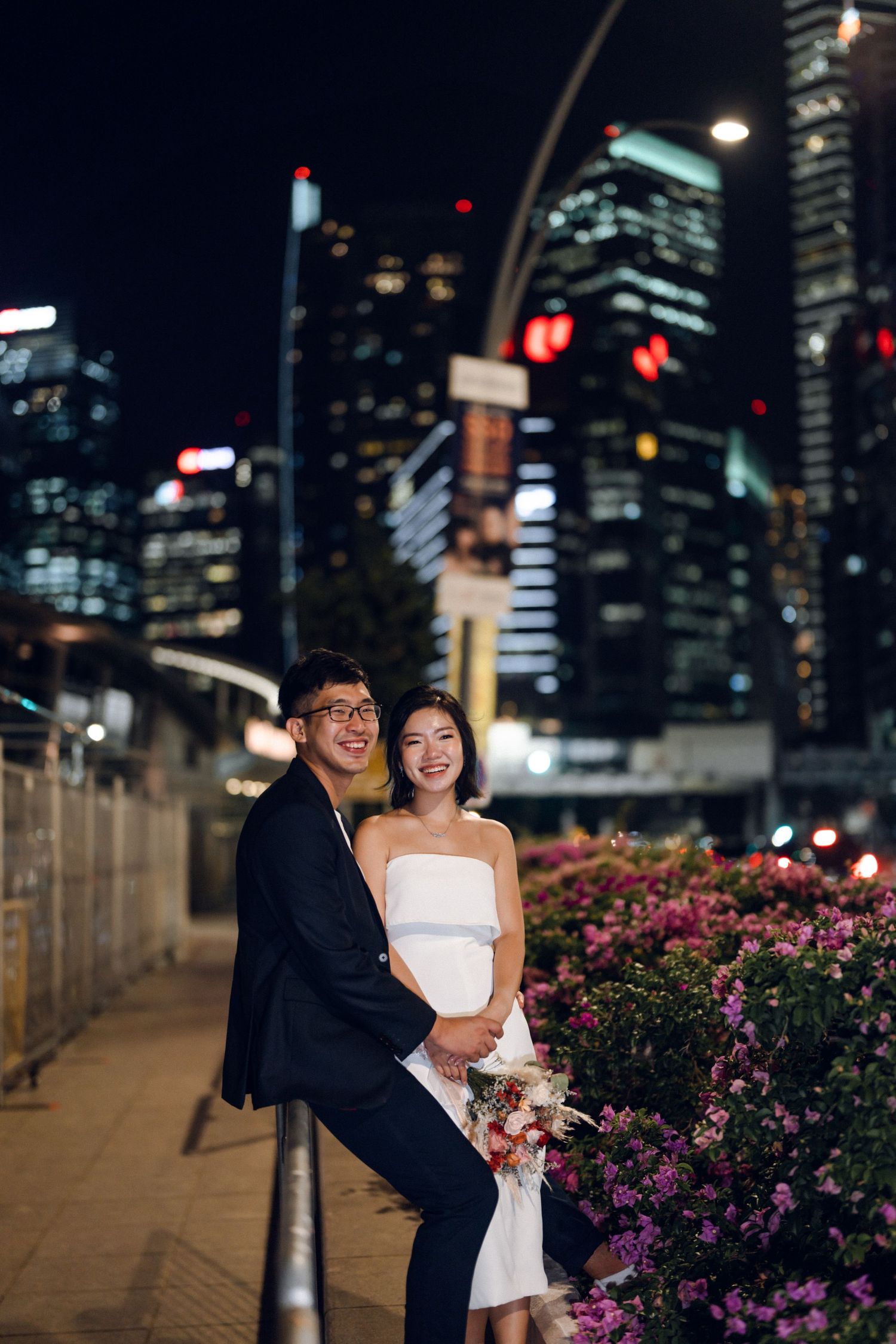 Intimate moment captured against Singapore skyline with pink bougainvillea flowers.