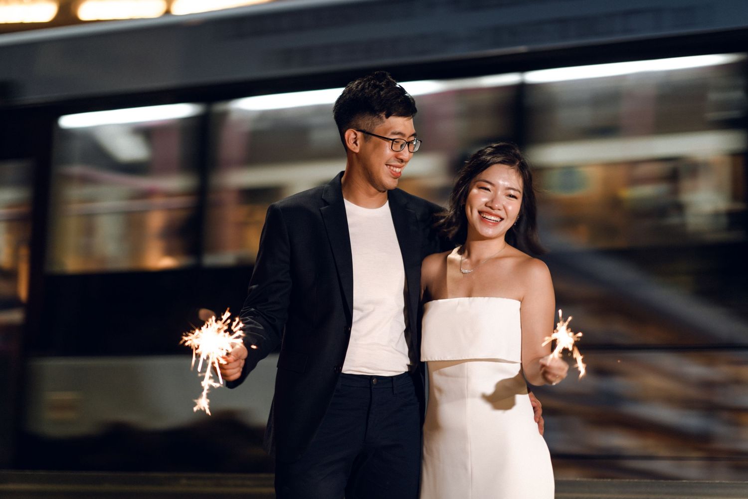 Couple sharing an intimate moment during nighttime sparkler celebration.