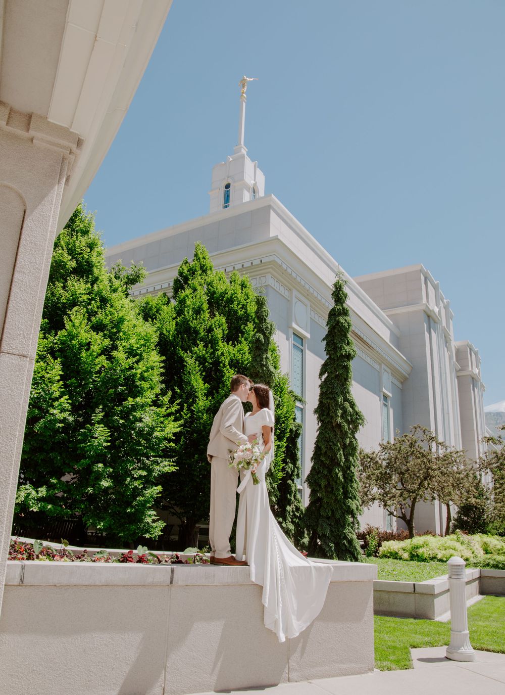 White temple building with ornate architecture against bright blue sky. Mount timp utah temple