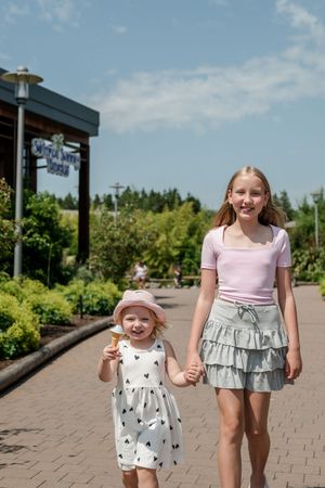Children walking and playing together on a brick pathway on a sunny summer day.