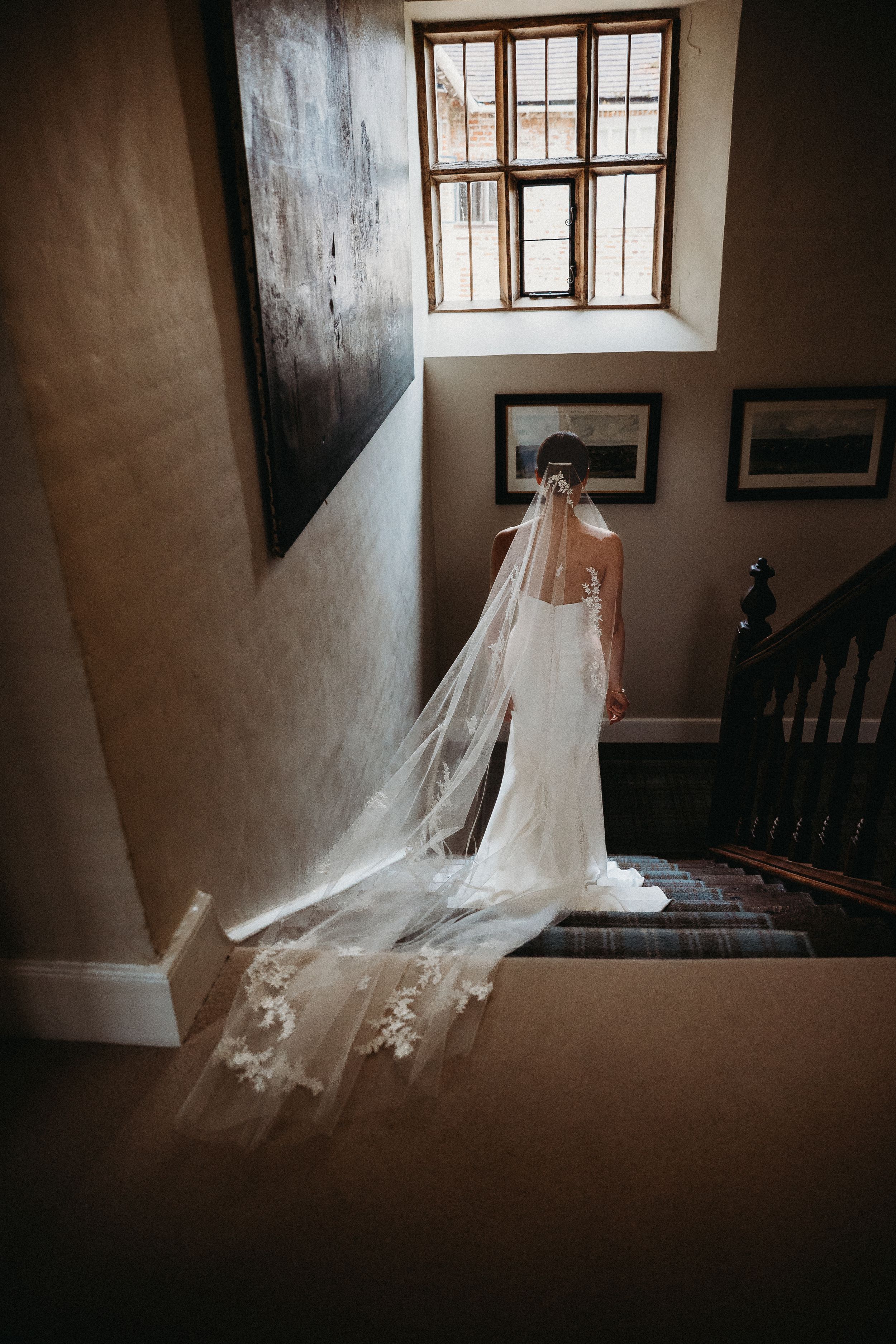 Bride walking down stairs to wedding ceremony at Bruisyard Country Estate