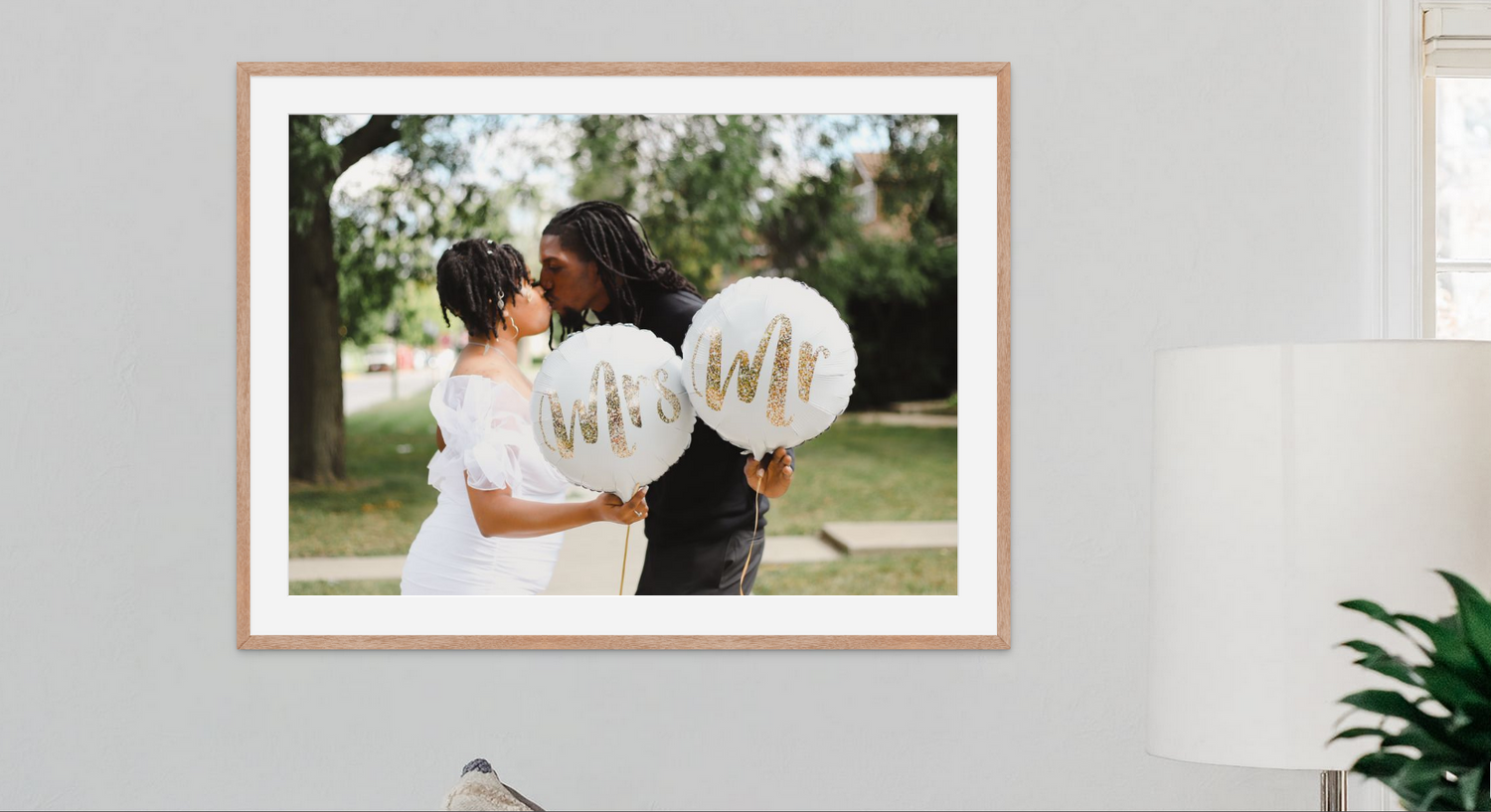 Image of a framed portrait of a wedding couple kissing. The portrait is hanging on the wall.