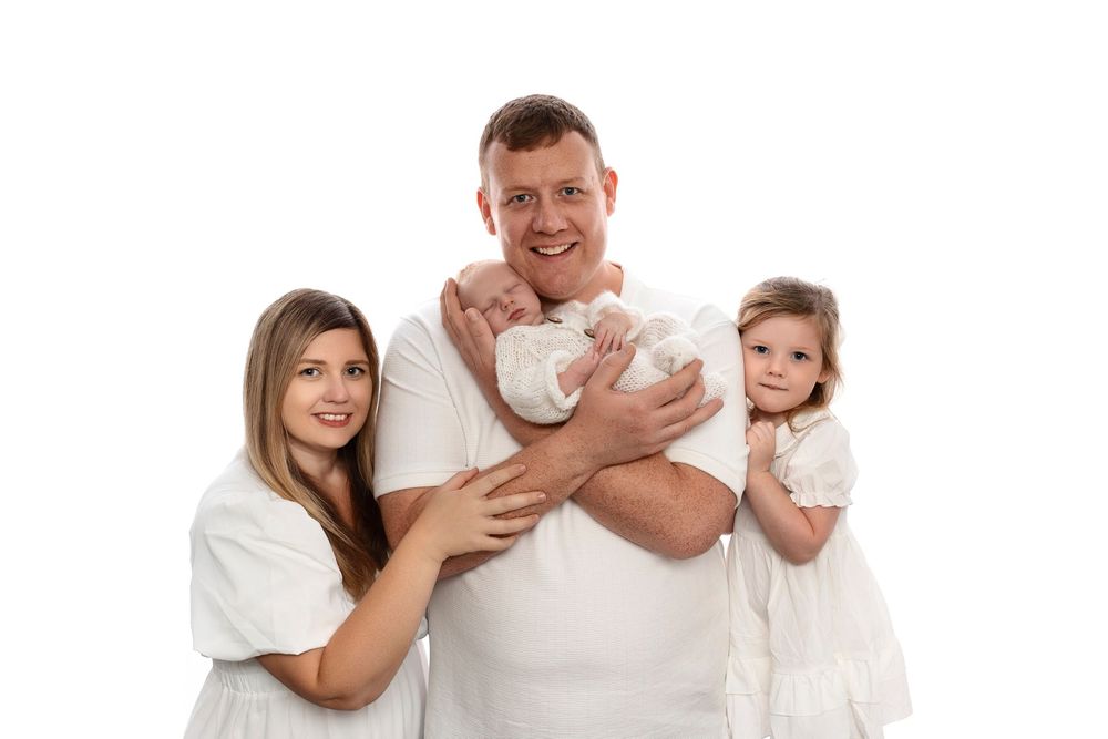 Family members in white clothing pose together in a series of connected portrait photos.