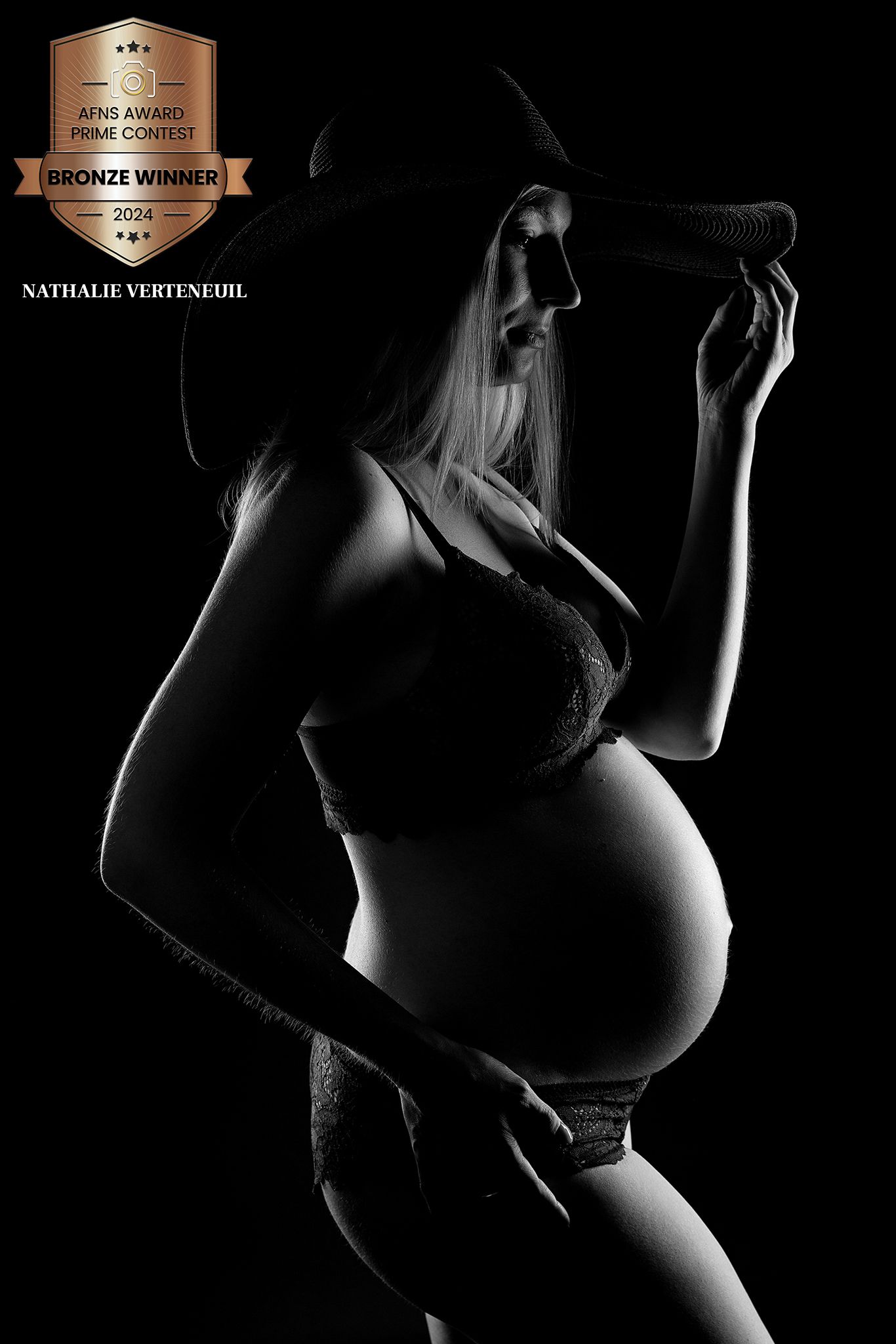 Dramatic silhouette of pregnant figure in artistic black and white photography.